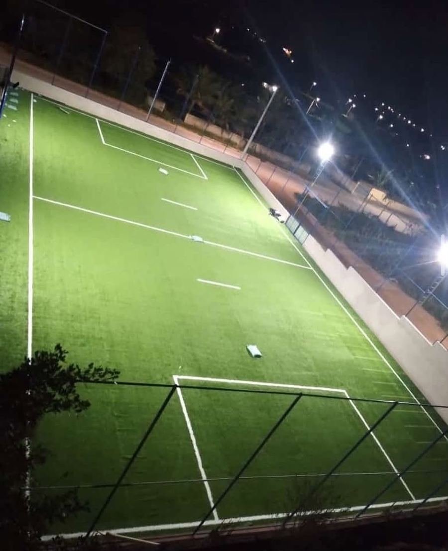 Campo de futebol com grama sintética iluminado à noite
