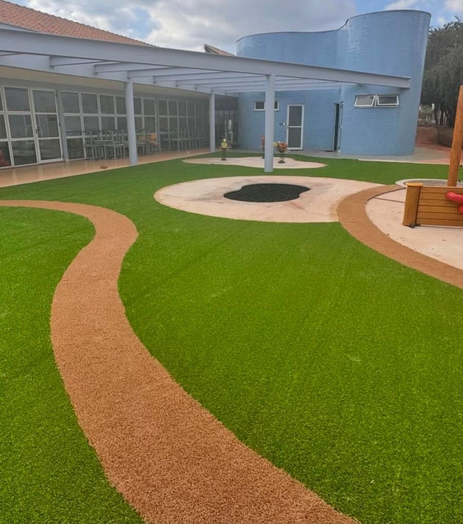 Área infantil com grama sintética e caminho